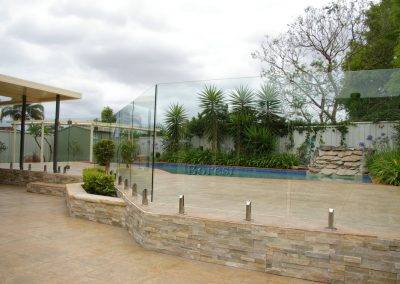 Frameless glass pool fencing done with retaining wall as a base instead of ground - we love the character it adds to this client's outdoor area in Adelaide suburbs