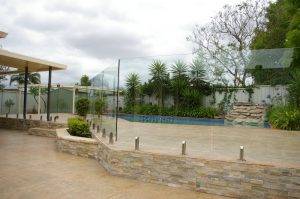Frameless glass pool fencing done with retaining wall as a base instead of ground - we love the character it adds to this client's outdoor area in Adelaide suburbs