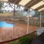 Frameless glass pool fence beside a timber deck