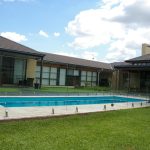 Frameless glass pool fencing on a landscaped Adelaide property